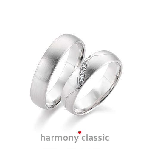 Produktfotografie des Trauringpaars Harmony Classic in Weißgold mit Diamanten und Verzierungen im Damenring