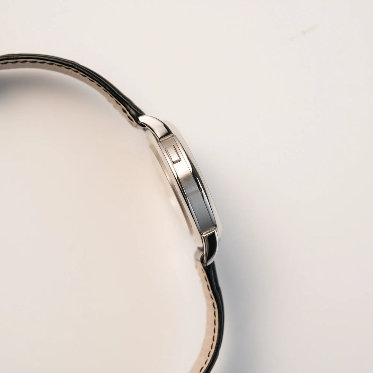 Seitliches Gehäuse der Großen Lange 1 mit Platingehäuse und silberfarbenem Zifferblatt am schwarzen Lederband von A. Lange & Söhne