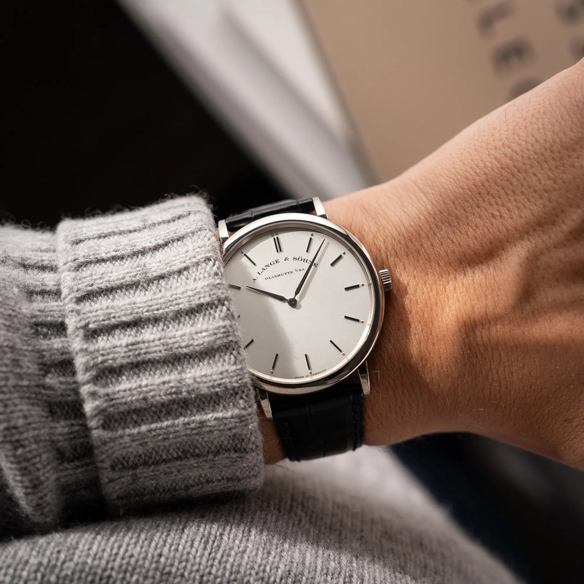 Wristshot mit der A.Lange Söhne Saxonia Thin der Referenz 211.026 im Weißgold-Gehäuse mit weiß-silbernem Zifferblatt am schwarzen Lederarmband