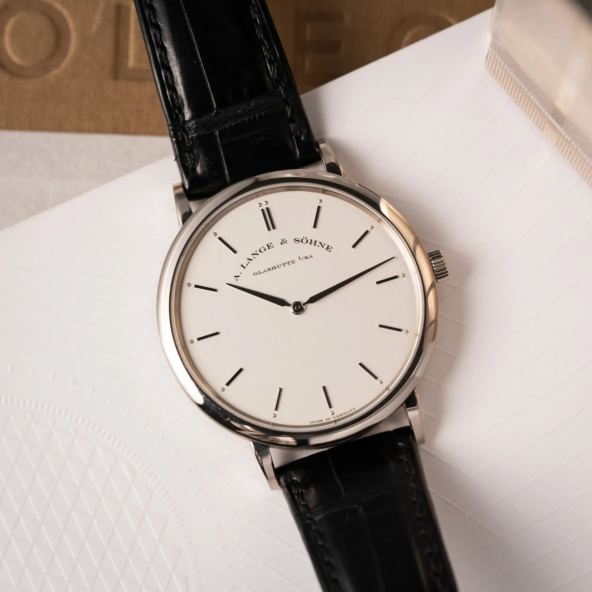 Detailaufnahme der A.Lange Söhne Saxonia Thin der Referenz 211.026 im Weißgold-Gehäuse mit weiß-silbernem Zifferblatt am schwarzen Lederarmband