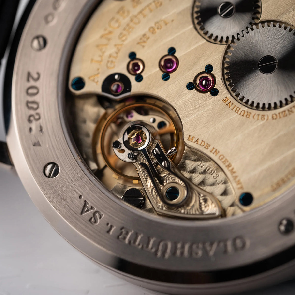 Detailaufnahme der A.Lange Söhne Saxonia Thin der Referenz 211.026 im Weißgold-Gehäuse mit weiß-silbernem Zifferblatt am schwarzen Lederarmband durch den Gehäuseboden mit Sichtglas
