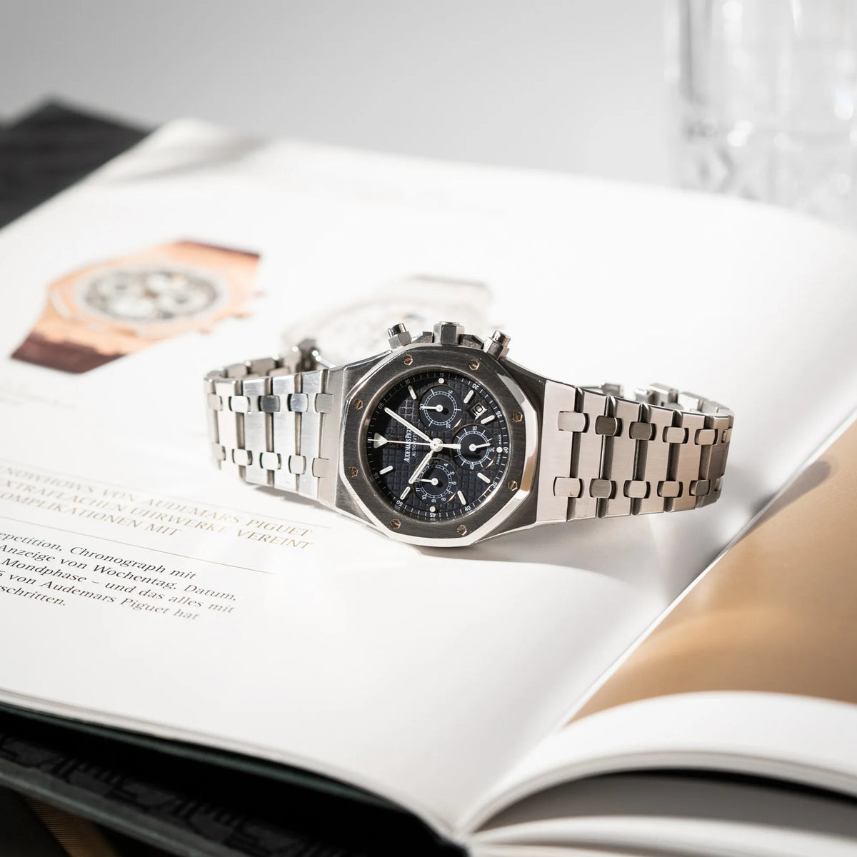 Audemars Piguet Royal Oak Chronograph Kasparov der Referenz 25860ST.mit blauem Tapisserie-Zifferblatt im 39mm-Edelstahl-Gehäuse liegt seitlich auf dem Uhrengehäuse