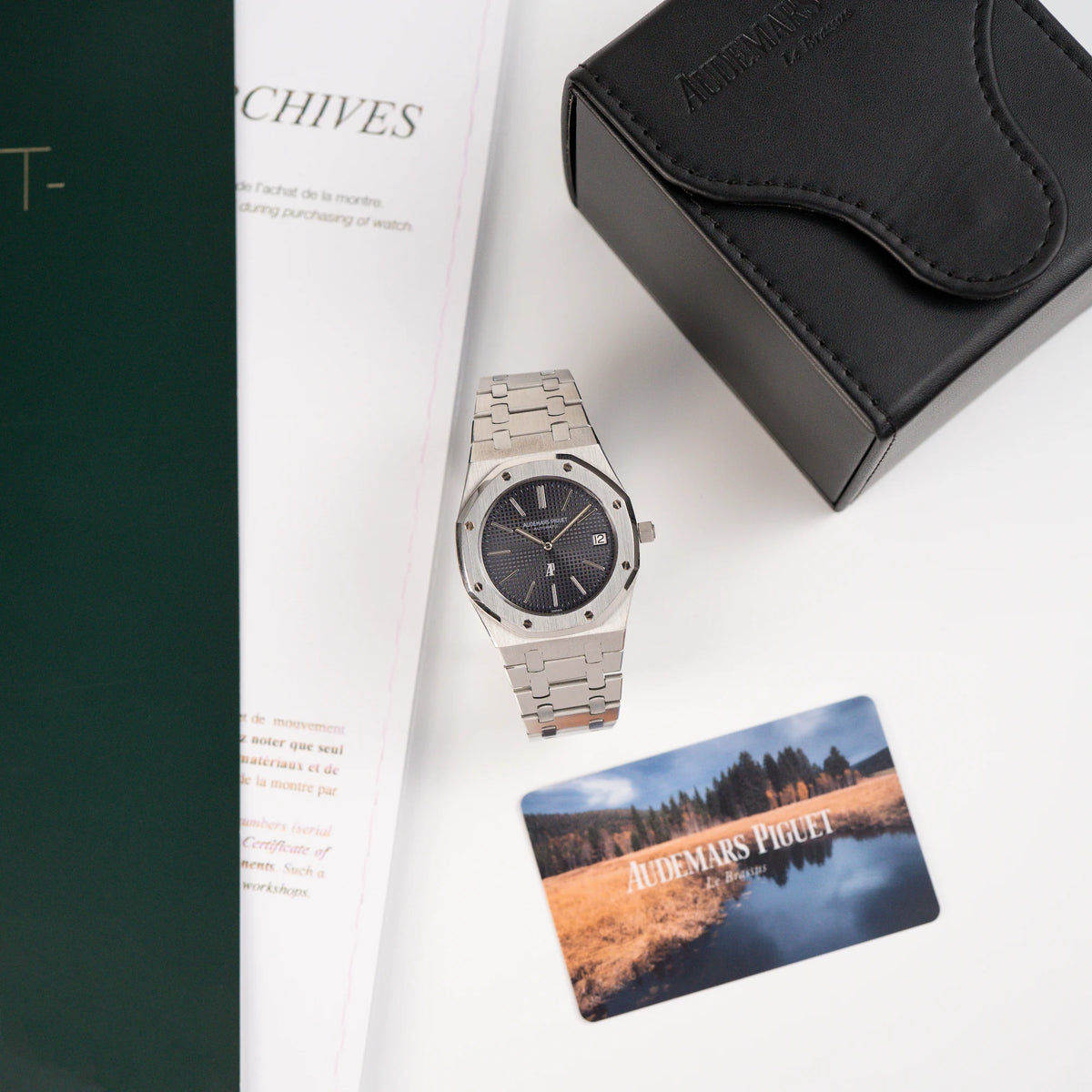 Audemars Piguet Royal Oak 5402ST aus der B-Serie in Stahl steht neben der Uhrenbox und daneben stehen Booklet und Zertifikat der Uhr