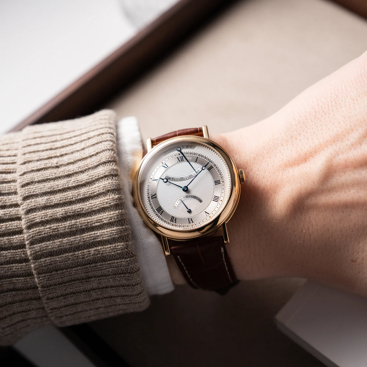 Wristhsot an Männerhandgelenk mit der gelbgoldenen Breguet Armbanduhr des Models Classic Retrograde 5207 am braunen Lederband
