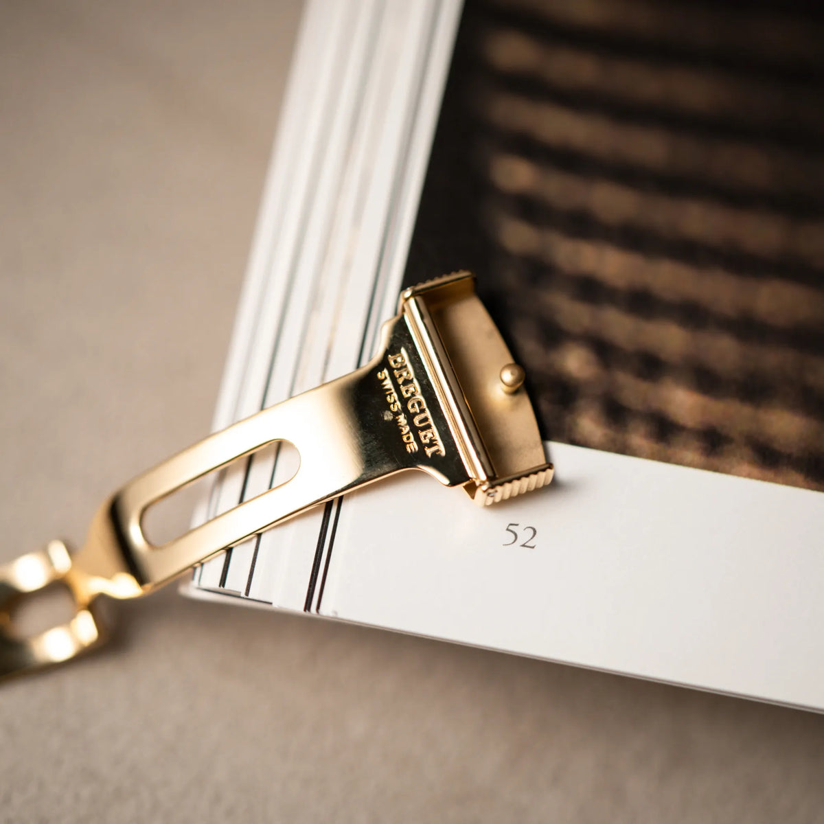Detailaufnahme der Breguet-Faltschliesse aus Gelbgold passend zu der gelbgoldenen Breguet Armbanduhr des Models Classic Retrograde 5207 am braunen Lederband