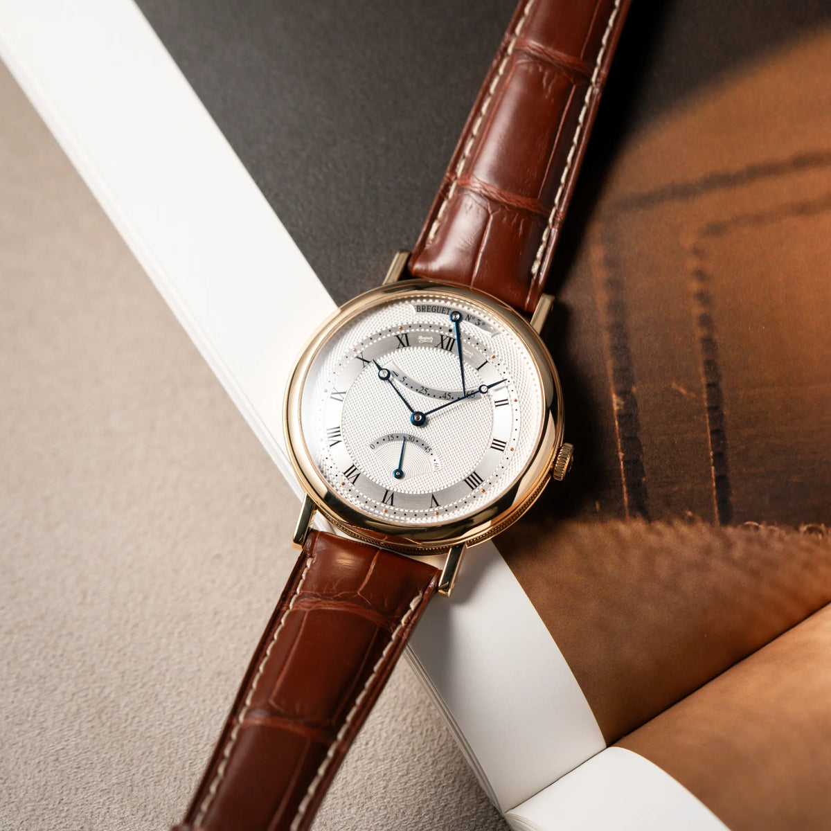 Produktfoto der gelbgoldenen Breguet Armbanduhr des Models Classic Retrograde 5207 am braunen Lederband