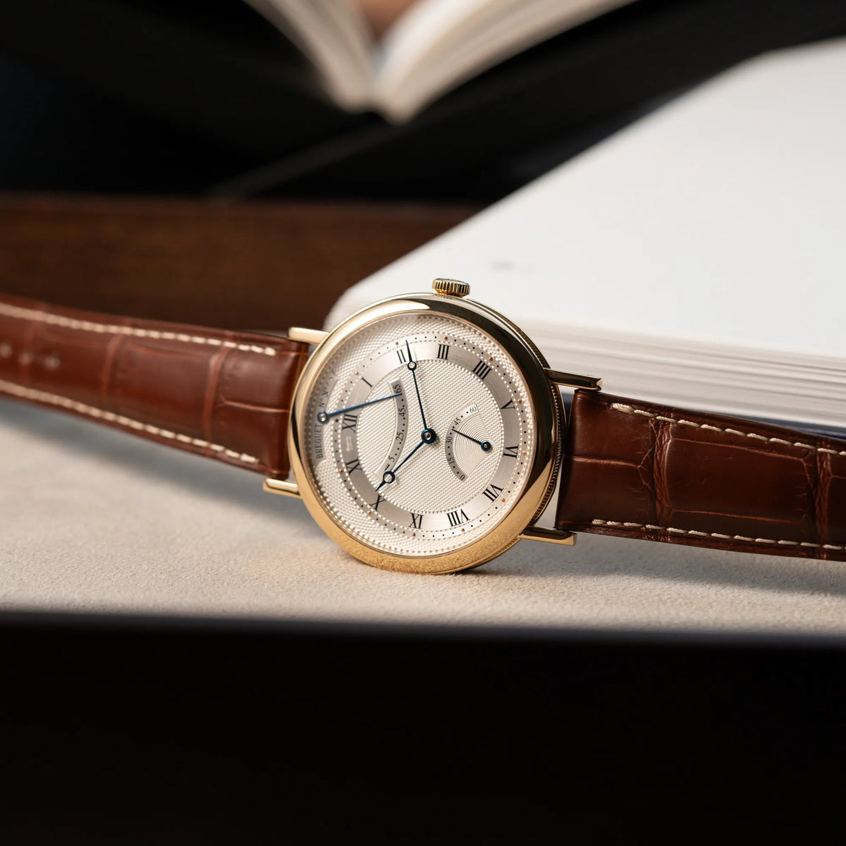 Fotografie der gelbgoldenen Breguet Armbanduhr des Models Classic Retrograde 5207 am braunen Lederband