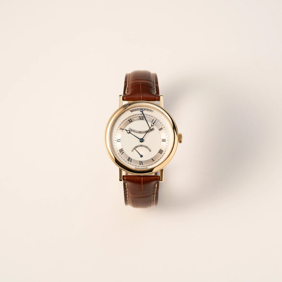 Frontale Ansicht der gelbgoldenen Breguet Armbanduhr des Models Classic Retrograde 5207 am braunen Lederband