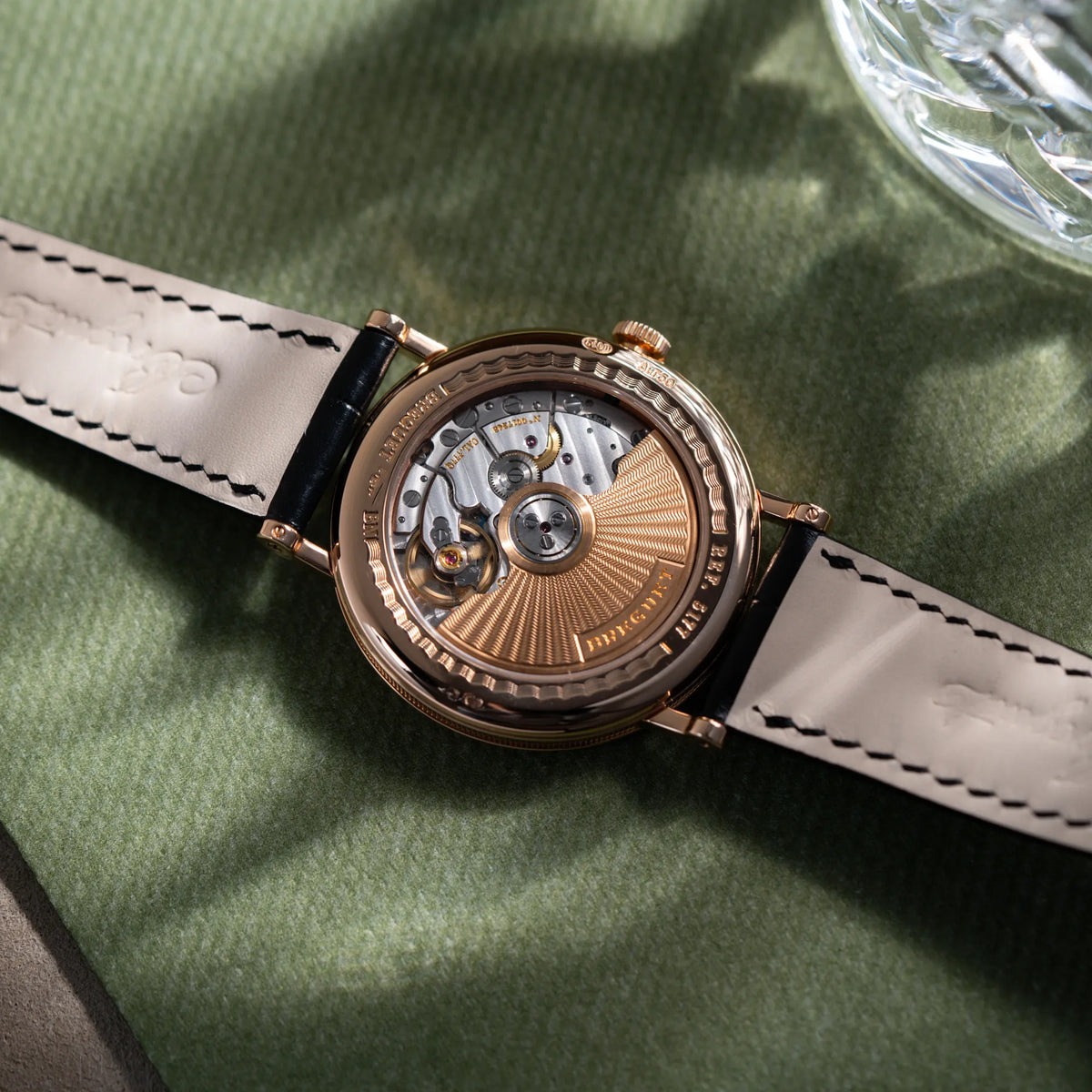 Sichtboden der Breguet Classique 5177 in Roségold mit weißem Emaille-Zifferblatt mit Blick auf das Uhrwerk