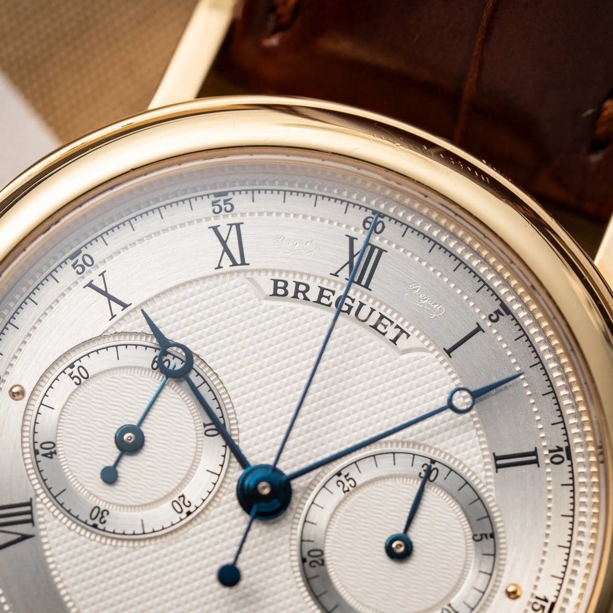 Detailaufnahme des gebläuten Ziegersatzes der Breguet Classique Chronograph der Referenz 5237 in Gelbgold mit silbernem guillochiertem Zifferblatt am braunem Lederband