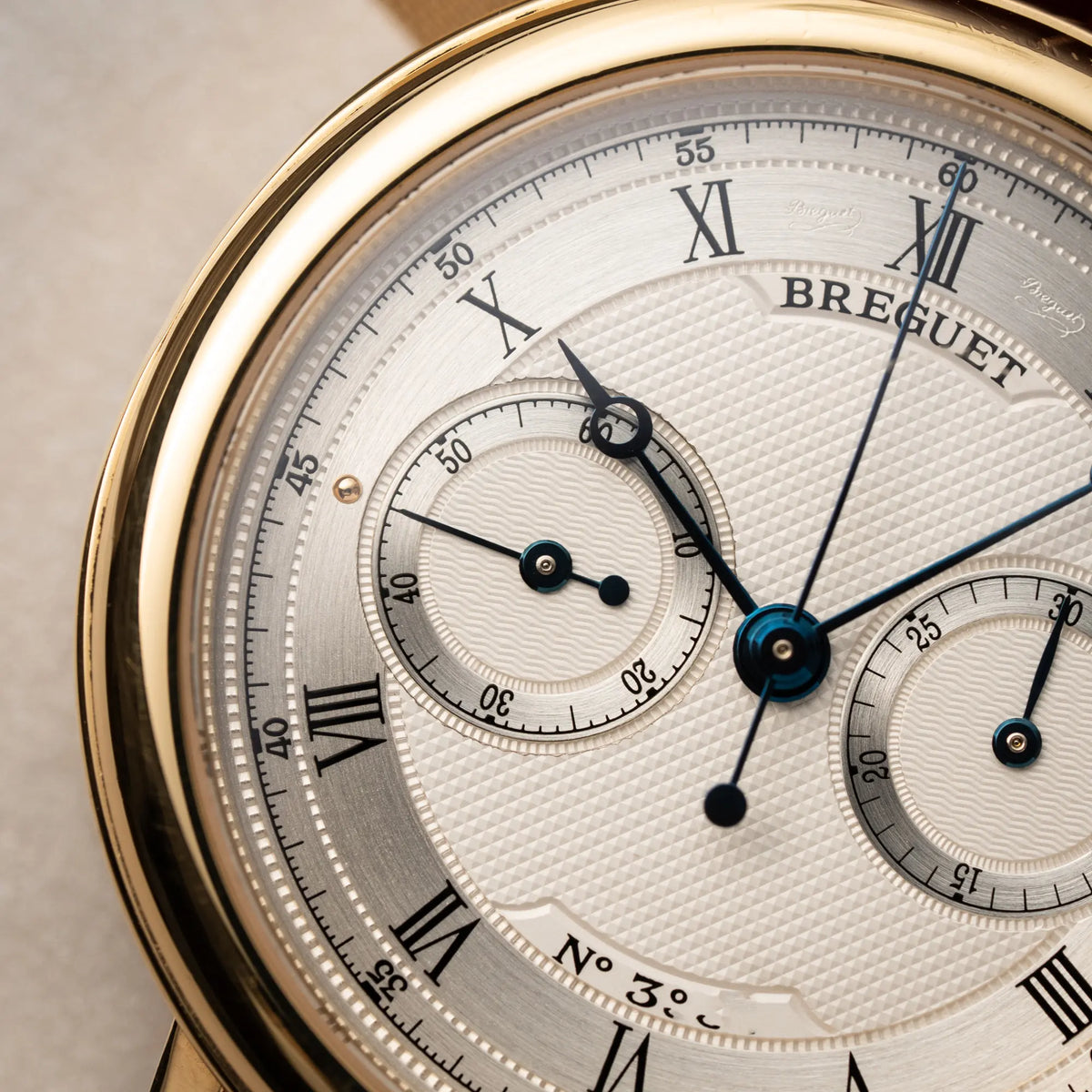 Produktfotografie der Breguet Classique Chronograph der Referenz 5237 in Gelbgold mit silbernem guillochiertem Zifferblatt am braunem Lederband mit Fokus auf dem linken Sub-Dial zur Anzeige der Sekunde