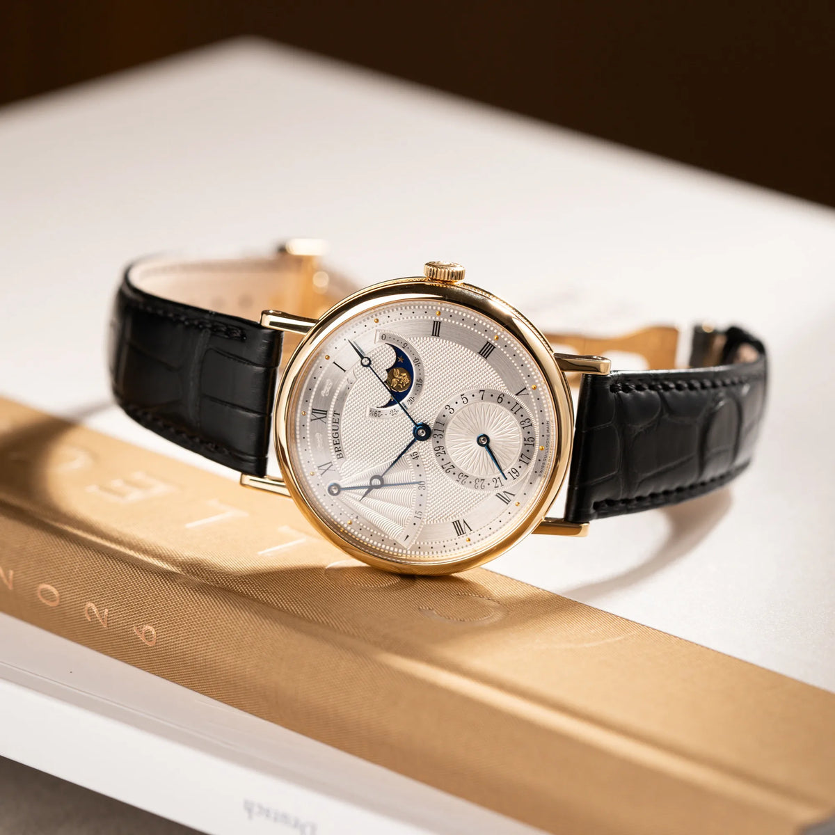 Produktfotografie der Breguet Classique Mondphase 7137 in Gelbgold mit silbernen, verschieden guillochiertem Zifferblatt