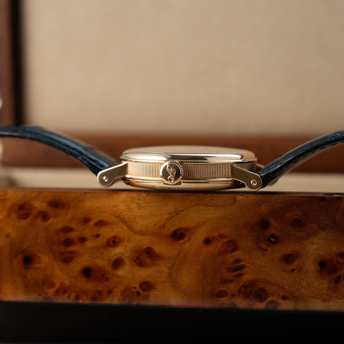 Produktfotografie der klassischen Breguet Tradition Armbanduhr mit Rosegold-Gehäuse und schwarzem Zifferblatt zeigt das seitliche Gehuse