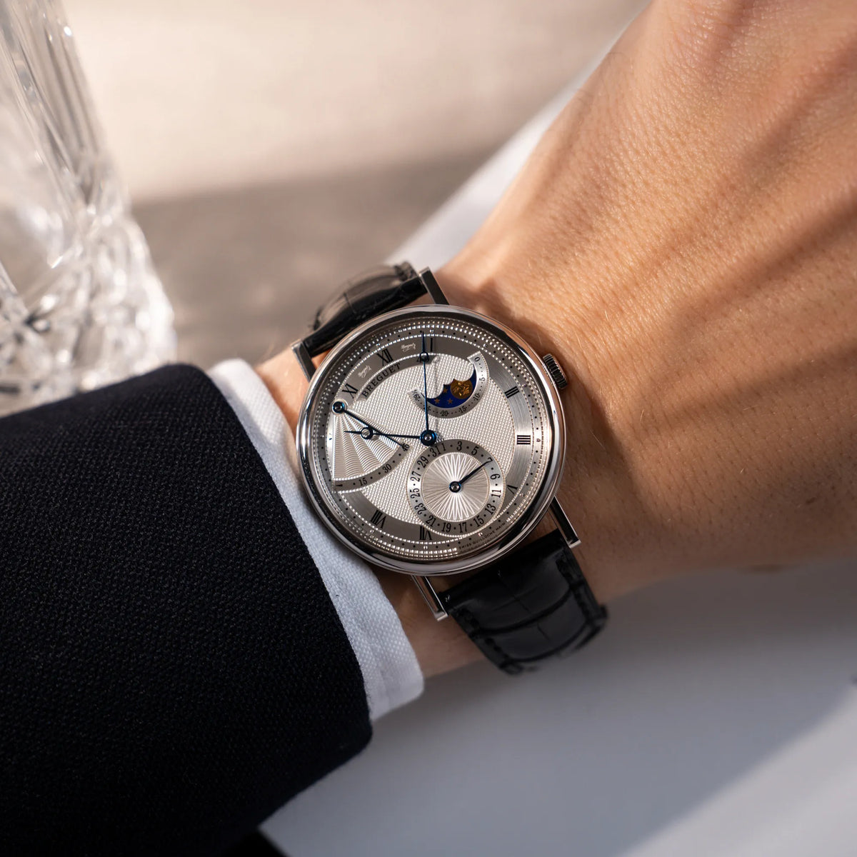 Wristshot mit der Breguet Classique Moonphase der Referenz 7137 in Weissgold mit 3-fach guillochiertem Zifferblatt und Mondphase-Anzeige