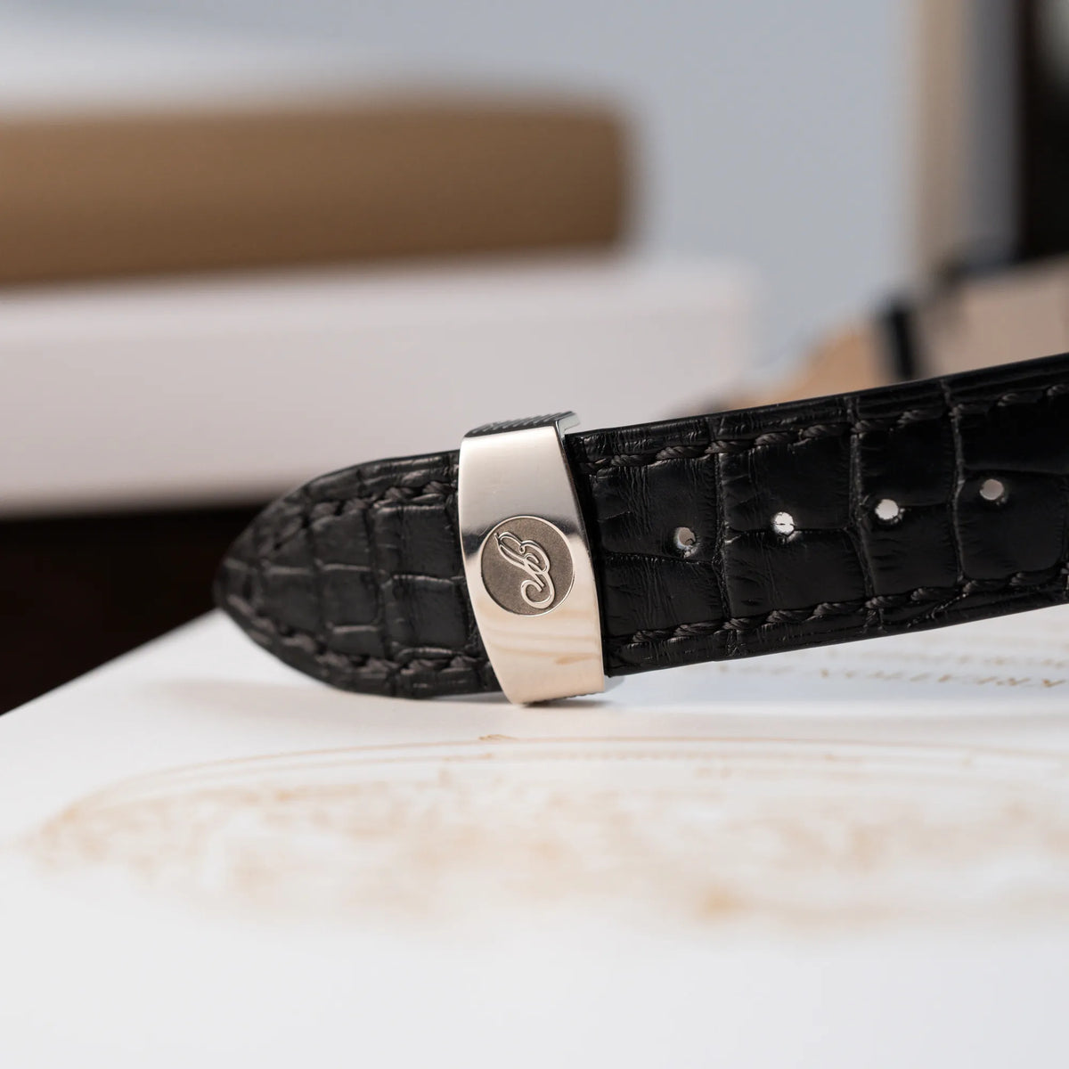 Detailaufnahme der originalen Breguet-Schliesse am schwarzen Lederband der Breguet Classique Moonphase der Referenz 7137 in Weissgold mit 3-fach guillochiertem Zifferblatt und Mondphase-Anzeige