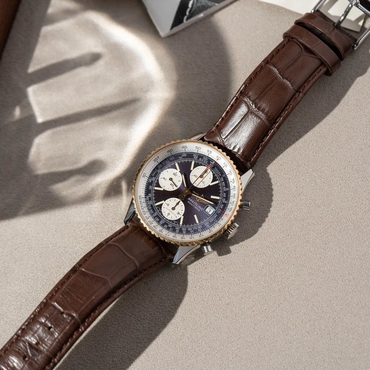 Produktfotografie des Breitling Old Navitimers mit Stahl-Gold-Gehäuse am braunen Lederband