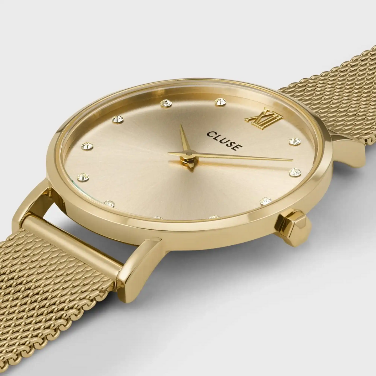 Leicht seitliche Detailansicht der goldfarbenen Cluse Damenuhr Minuit CW10204 mit rundem Gehäuse, einem goldfarbenem Zifferblatt mit Zirkonia-Steinen als Indizes und einem feinem Mesh-Uhrenarmband