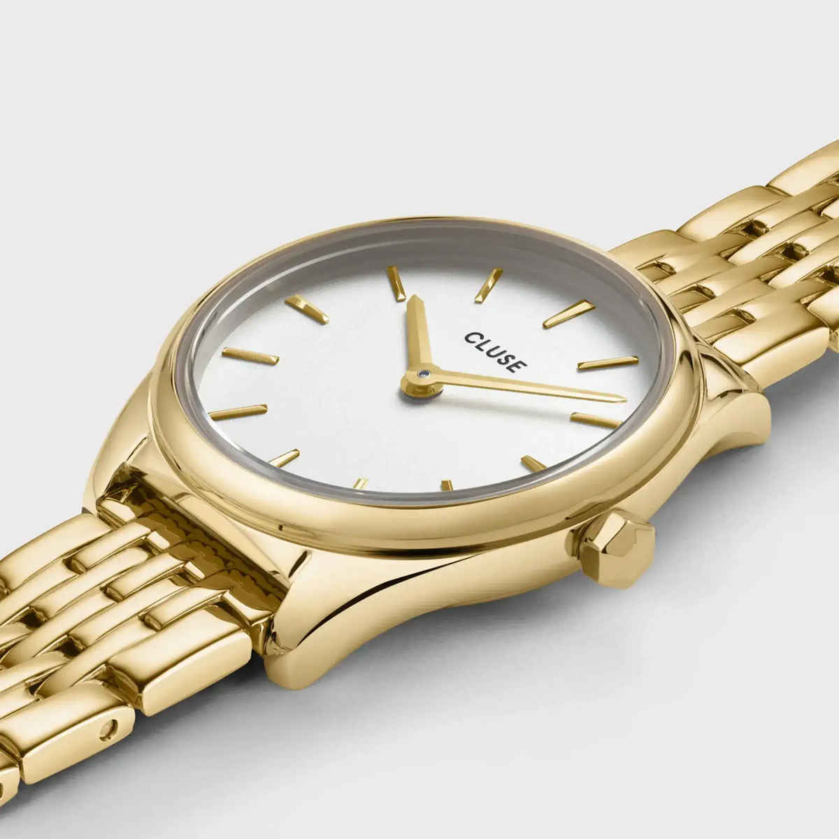 Leicht schräge Detailansicht der goldfarbenen Cluse Damenuhr Feroce Mini CW11705 mit rundem Gehäuse, einem weißem Zifferblatt und einem feingliedrigem, goldfarbenem Uhrenarmband