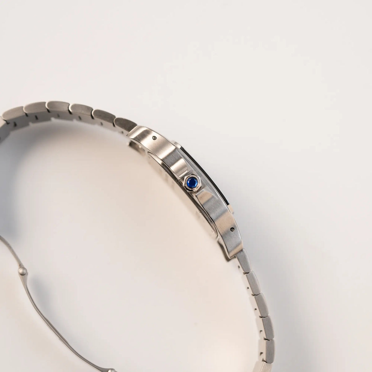 Seitliches Gehäuse der Cartier Santos Galbée 2823 in Edelstahl mit weißem Zifferblatt mit Blick auf die Aufzugkrone