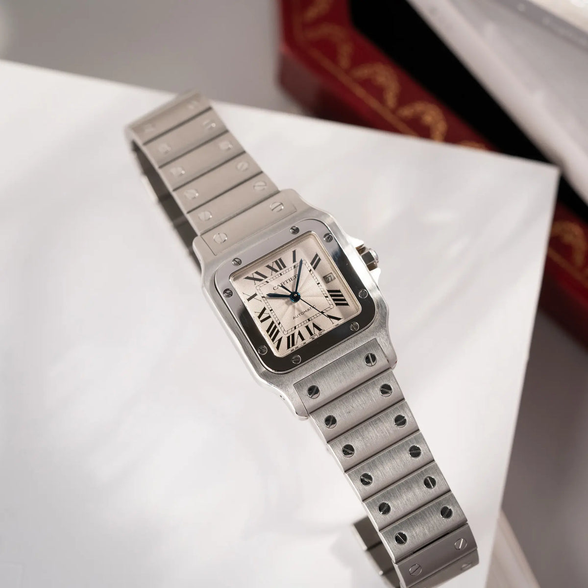 Produktfotografie der Cartier Santos Galbée 2913 in Edelstahl mit weiß-silbernem Zifferblatt am Stahlband mit der klassischen Cartier-Schrauben-Optik