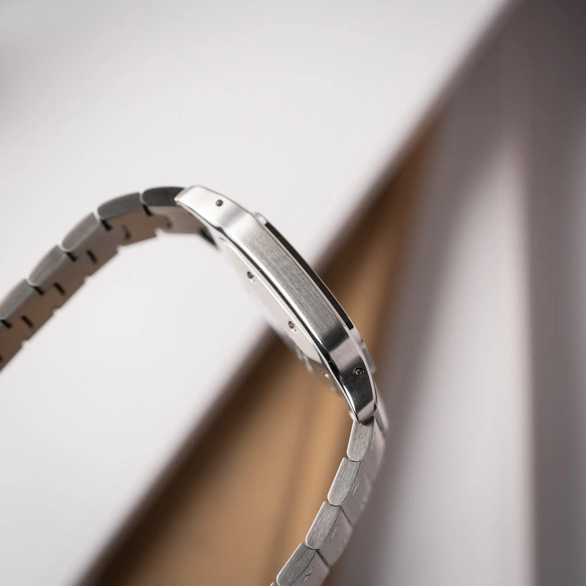 Seitliche Gehäuseflanke der Cartier Santos Galbée 2913 in Edelstahl mit weiß-silbernem Zifferblatt am Stahlband mit der klassischen Cartier-Schrauben-Optik