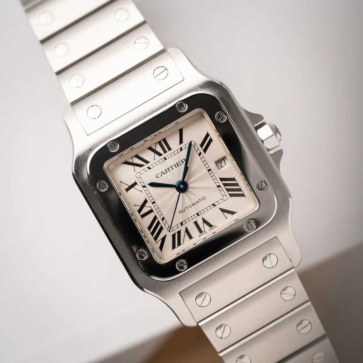 Detailaufnahme der Cartier Santos Galbée 2913 in Edelstahl mit weiß-silbernem Zifferblatt am Stahlband mit der klassischen Cartier-Schrauben-Optik zeiugt den Uhrenkopf