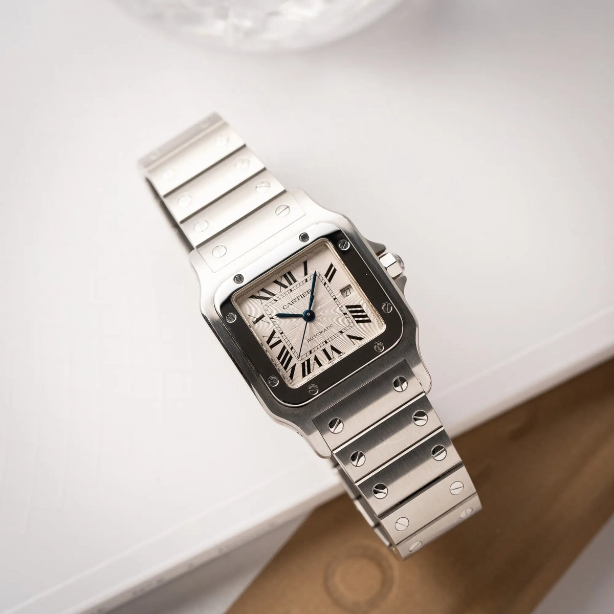 Produktfotografie als Titelbild für die Cartier Santos Galbée 2913 in Edelstahl mit weiß-silbernem Zifferblatt am Stahlband mit der klassischen Cartier-Schrauben-Optik