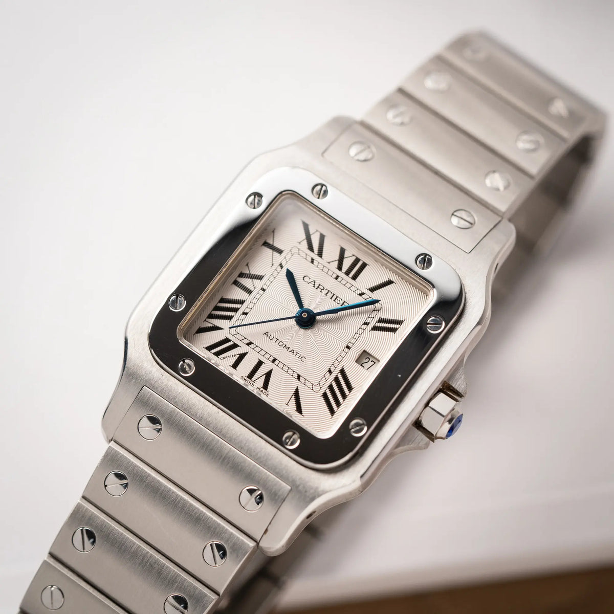 Detailaufnahme der Cartier Santos Galbée 2913 in Edelstahl mit weiß-silbernem Zifferblatt am Stahlband mit der klassischen Cartier-Schrauben-Optik