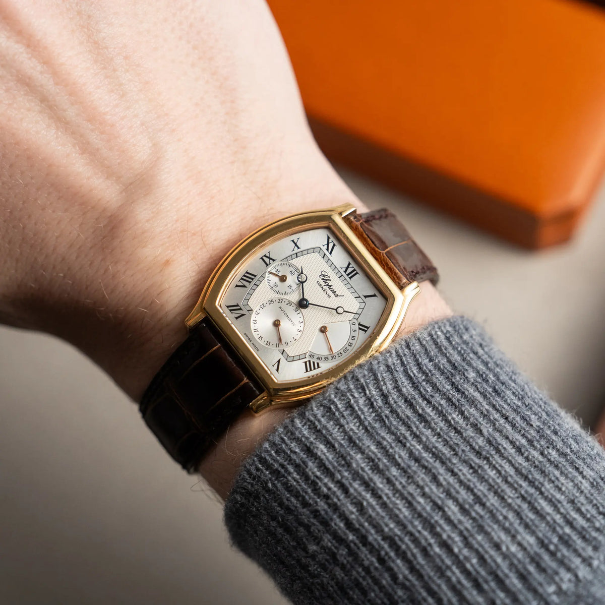 Mann präsentiert die Chopard Tonneau Powerreserve 2248 mit Gehäuse aus 18k Roségold an seinem Handgelenk in die Kamera