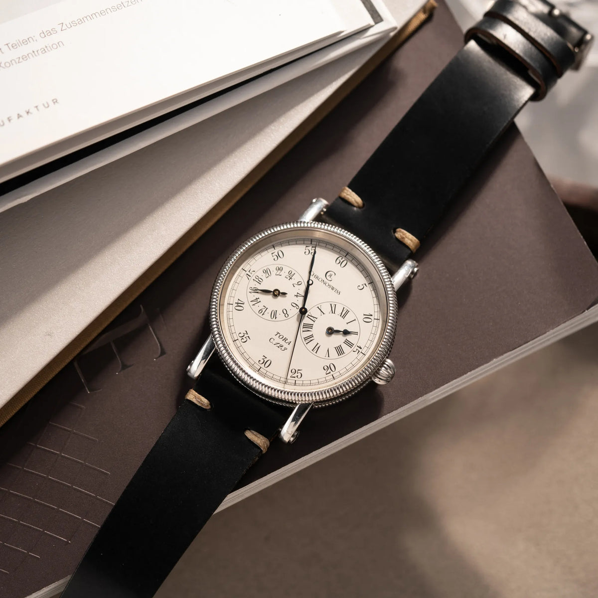 Produktfotografie der Chronoswiss Regulator Tora C123 mit weißem Zifferblatt mit zwei symmetrisch angeordneten Hilfszifferblättern mit römischen Indizes