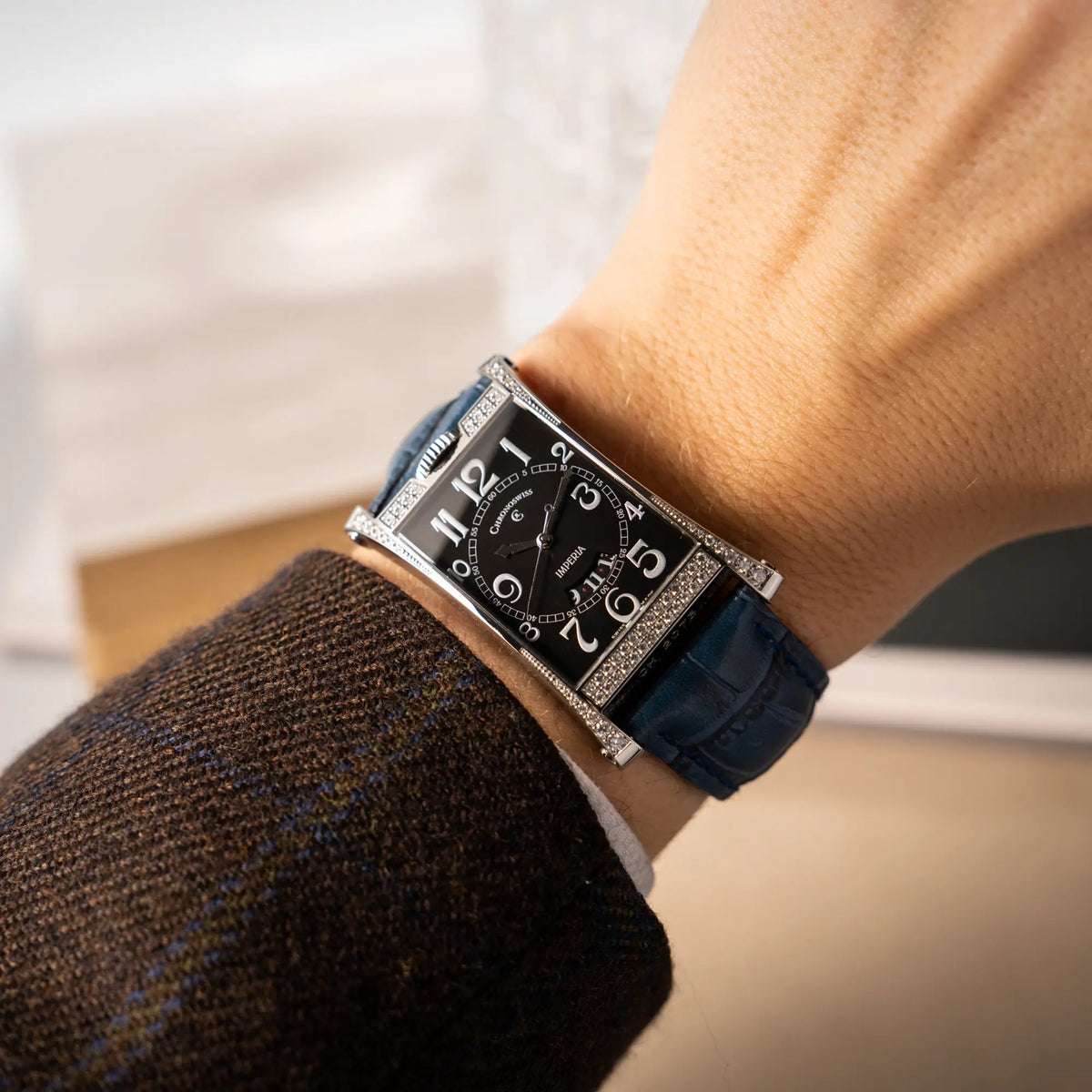 Wristshot mit der Chronoswiss Imperia Constanze mit diamantbesetzten-Stahlgehäuse mit schwarzem Zifferblatt an einem petrol-blauem Lederband