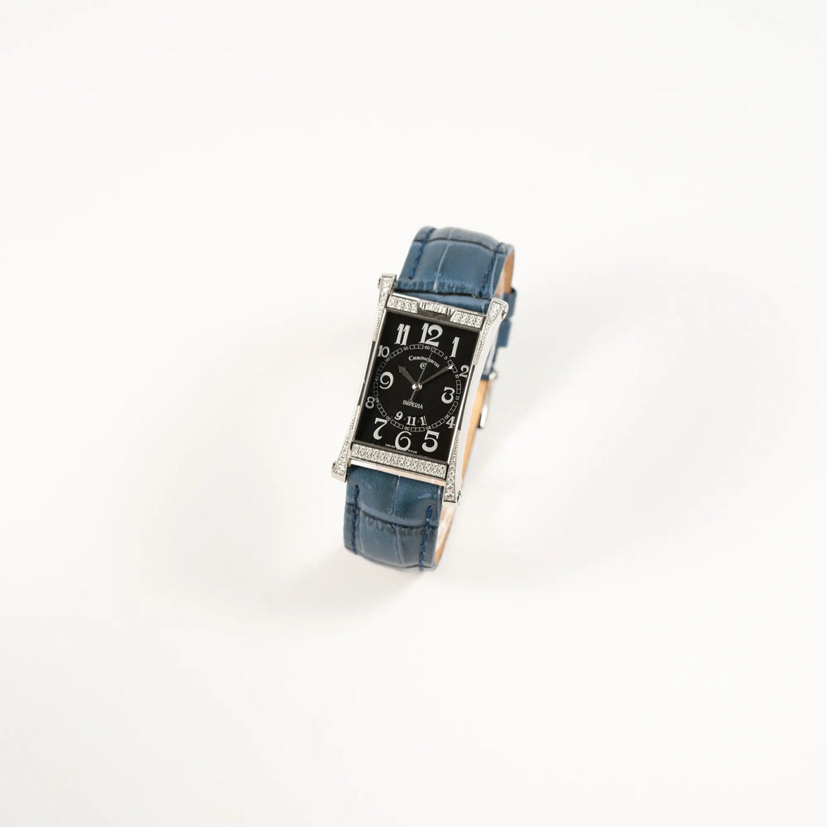 Leicht schräge Ansicht der Chronoswiss Imperia Constanze mit diamantbesetzten-Stahlgehäuse mit schwarzem Zifferblatt an einem petrol-blauem Lederband