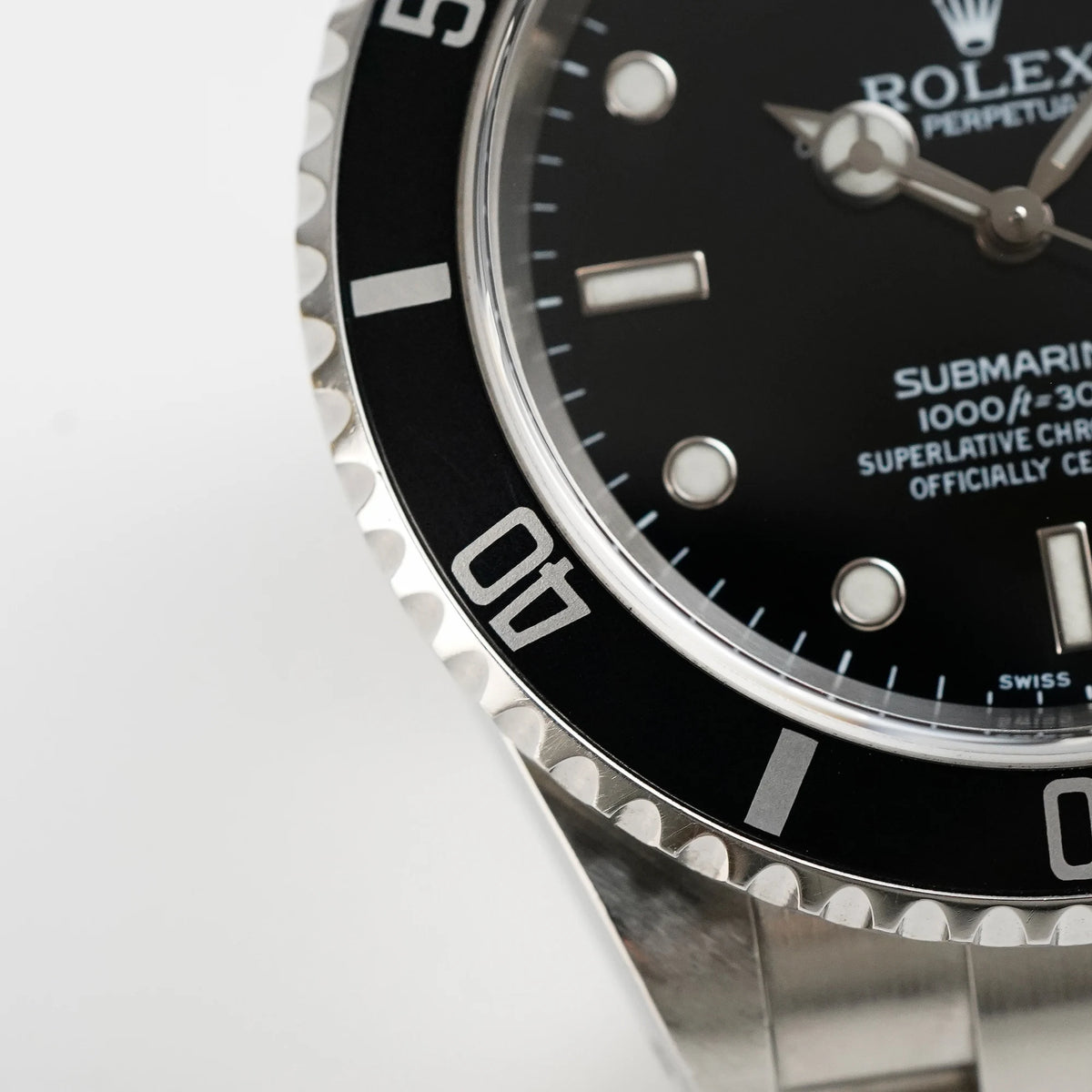Makroaufnahme der Lünette mit Flat-Four der Rolex Submariner Date in schwarz, Referenz 16610