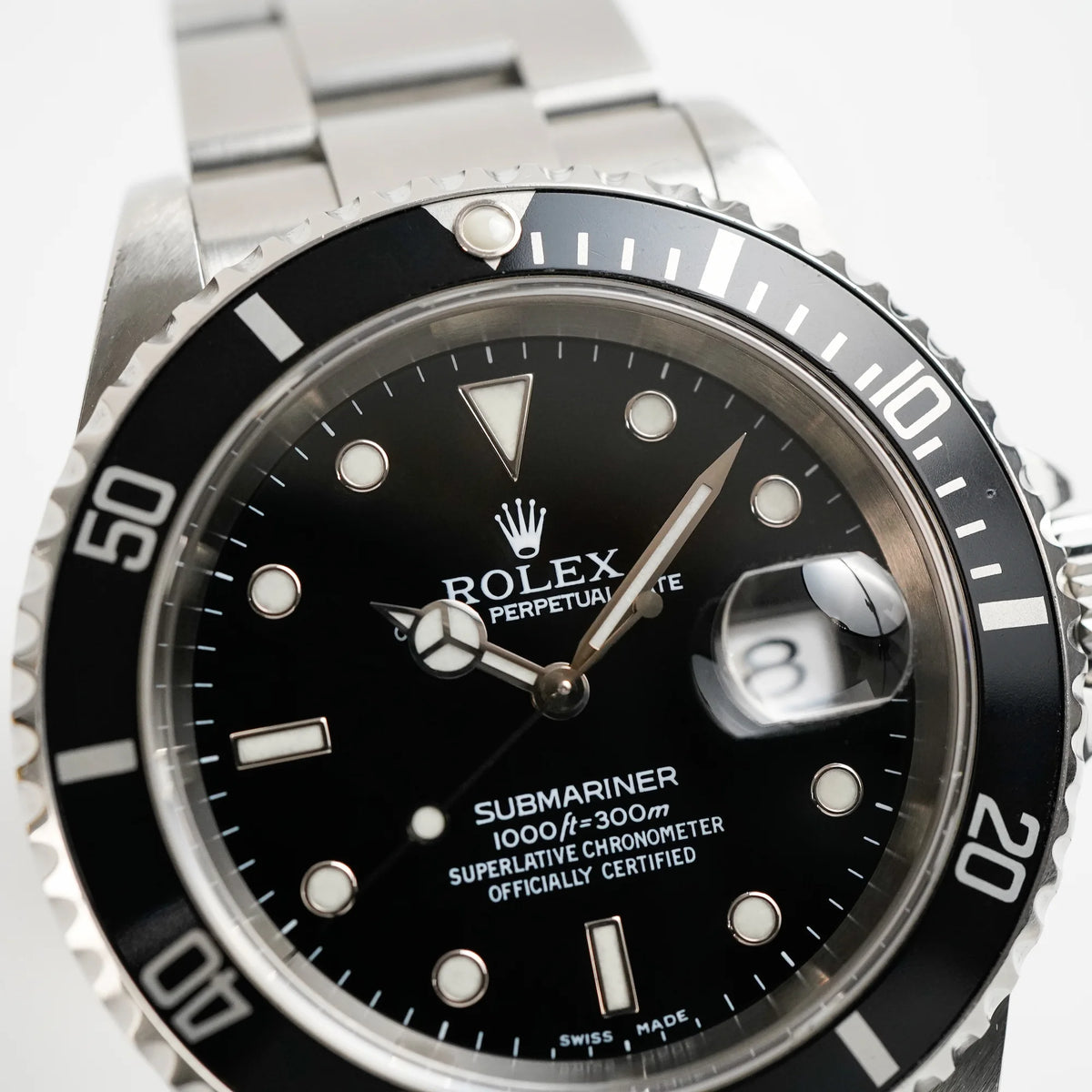 Detailaufnahme der Rolex Submariner Date in schwarz, Referenz 16610, mit Flat-Four-Lünette