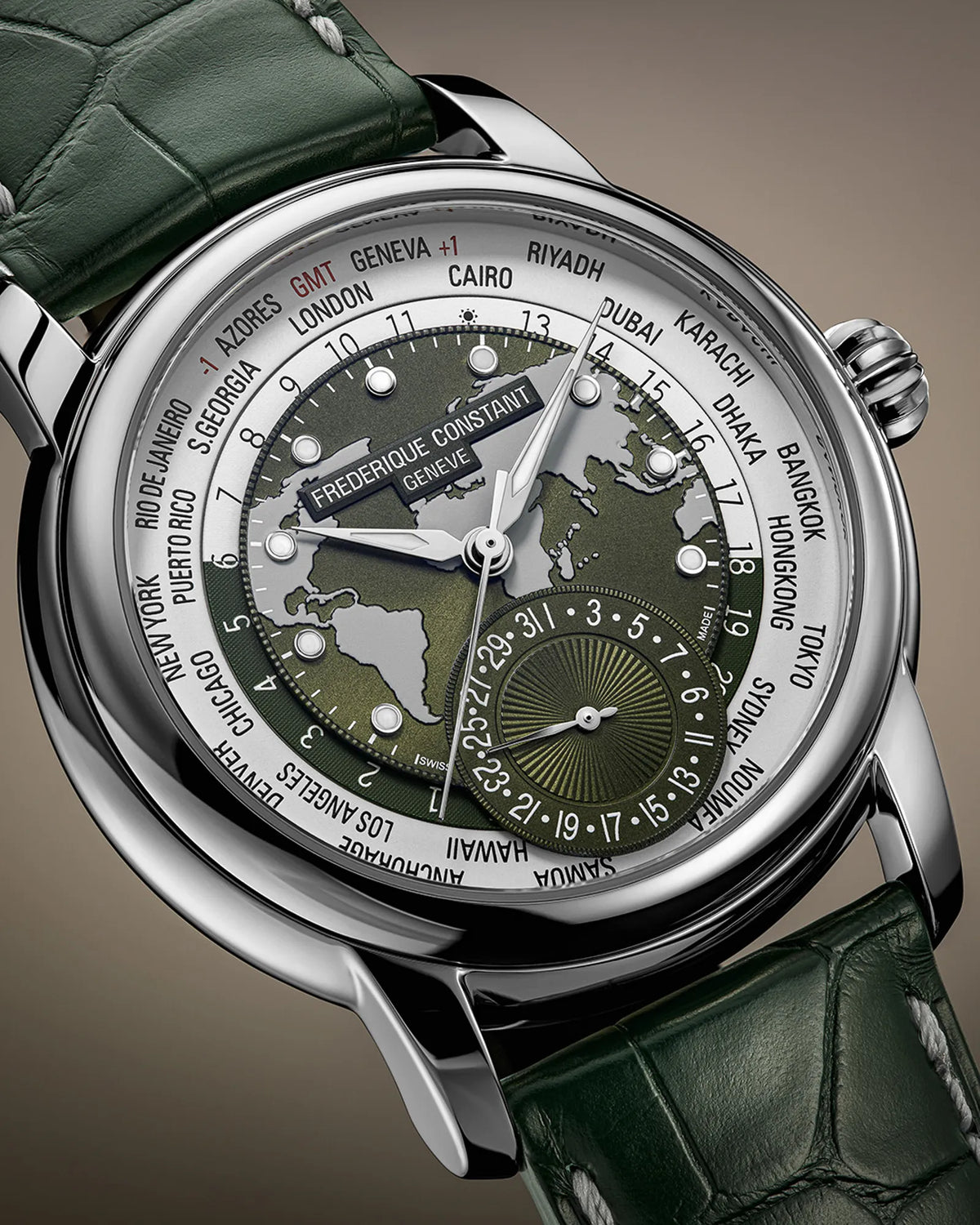 Detailaufnahme des Uhrenkopfes der Manufacture Worldtimer von Frederique Constant in Grün mit Weltkarten-Zifferblatt