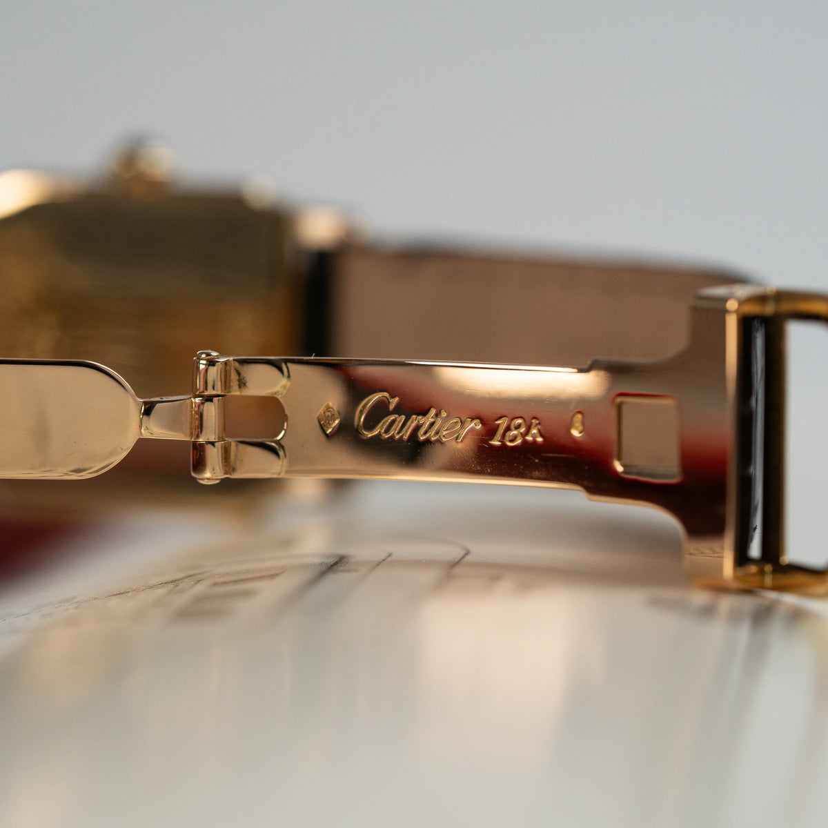 Detailaufnahme der goldenen Faltschließe aus 18 Karat für die Cartier Santos Dumont "Deux Ors"
