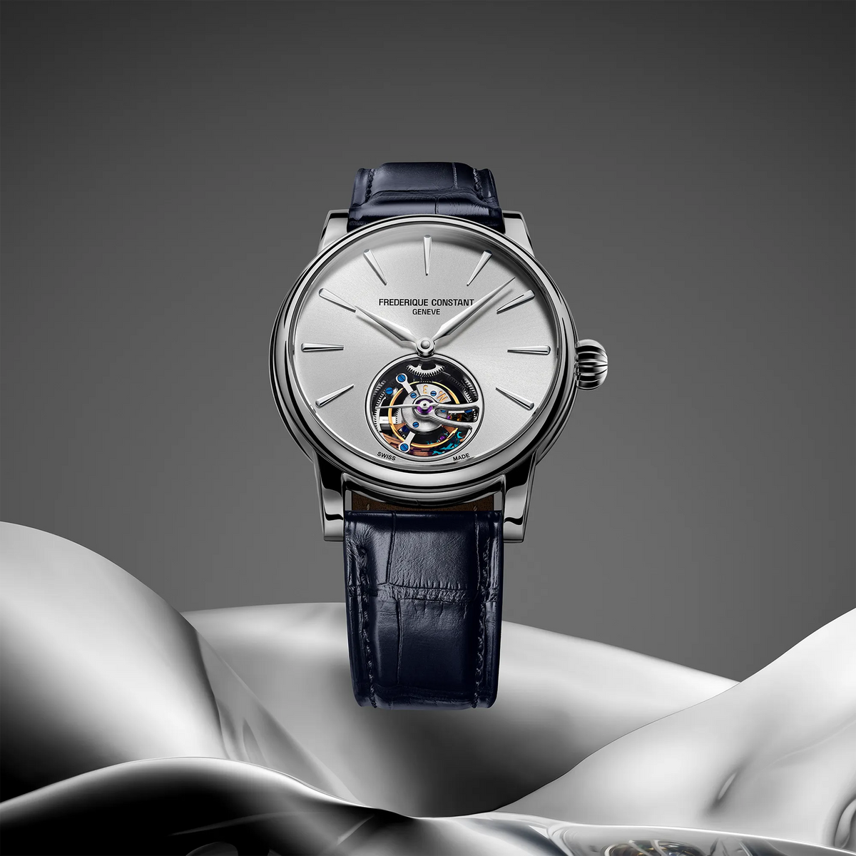 Produktfotografie der Frederique Constant Manufacture Classic Tourbillon FC-980S3H6 in Stahl mit silberfarbenem Zifferblatt und Tourbillon-Käfig bei 6 Uhr an einem dunkelblauen Alligator-Lederband