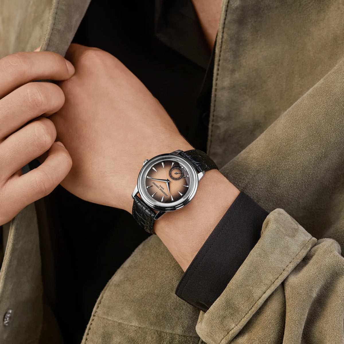 Frau trägt die Frederique Constant Moneta Handaufzug Limited Edition der Referenz FC-435BBL3S6 mit braun-schwarz verlaufendem Ombre-Dial am schwarzen Lederband an seinem Handgelenk