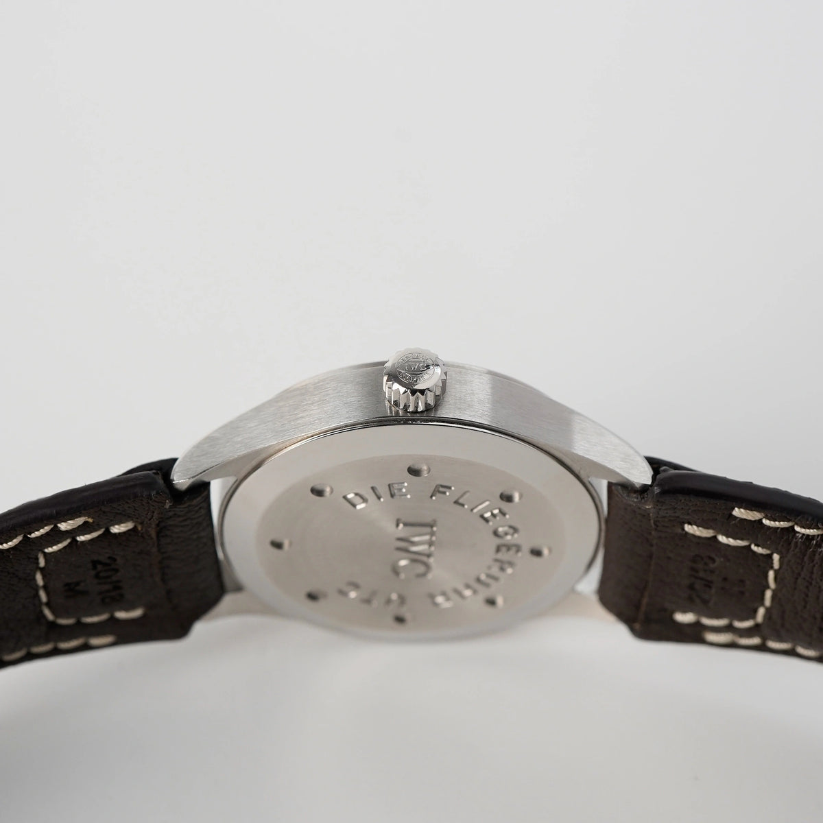 Blick auf die Krone und den Gehäuseboden IWC Schaffhausen Pilot Fliegeruhr UTC Spitfire mit der Referenz IW3251 mit braunem Lederband