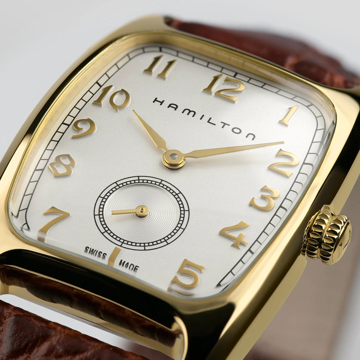 Detailaufnahme der goldfarbene Hamilton American Classic Boulton mit ihrem länglichen Uhrengehäuse an einem braunen Lederband