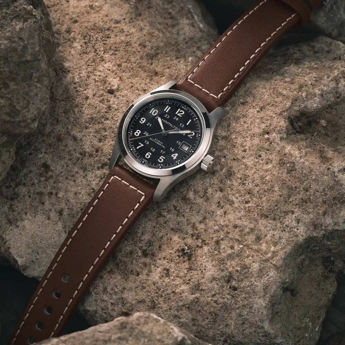 Produktfotografie der Hamilton Khaki Field Auto H70455533 mit schwarzem Zifferblatt an einem braunen Lederband