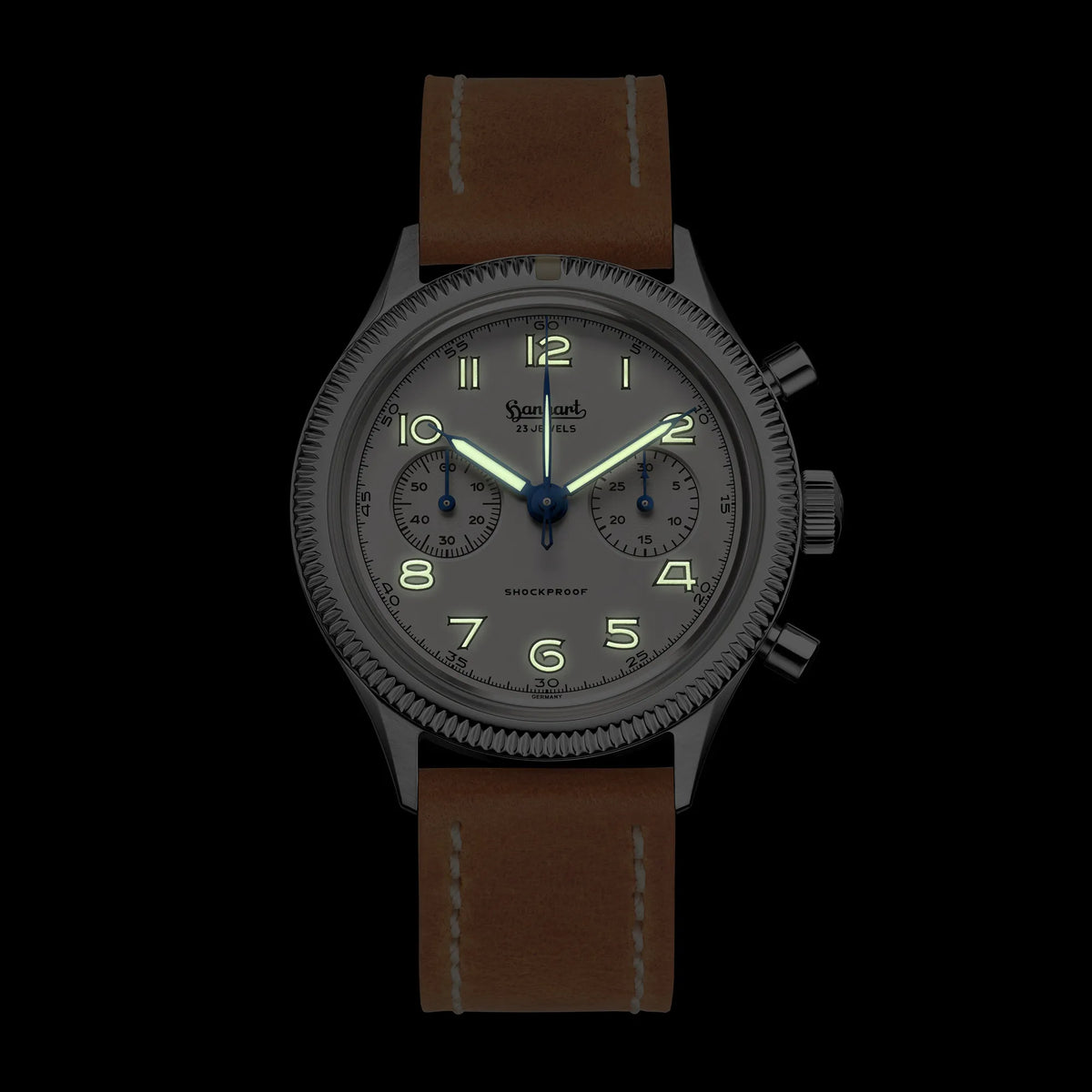 Hanhart 417 ES "Moby Dick" Chronographs mit 42mm-Gehäuse und weißem Zifferblatt am hellbraunen Lederband bei Nacht mit Leuchtmasse in Zeiger und Ziffer