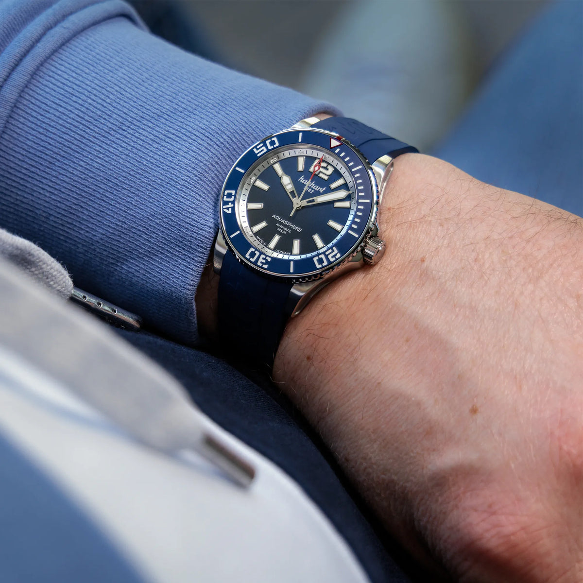Mann trägt die Hanhart Aquasphere mit dem blau-schwarz verlaufenden "Ocean Fade"-Zifferblatt und blauem Keramik-Inlay auf der Lünette am Edelstahlarmband am Handgelenk