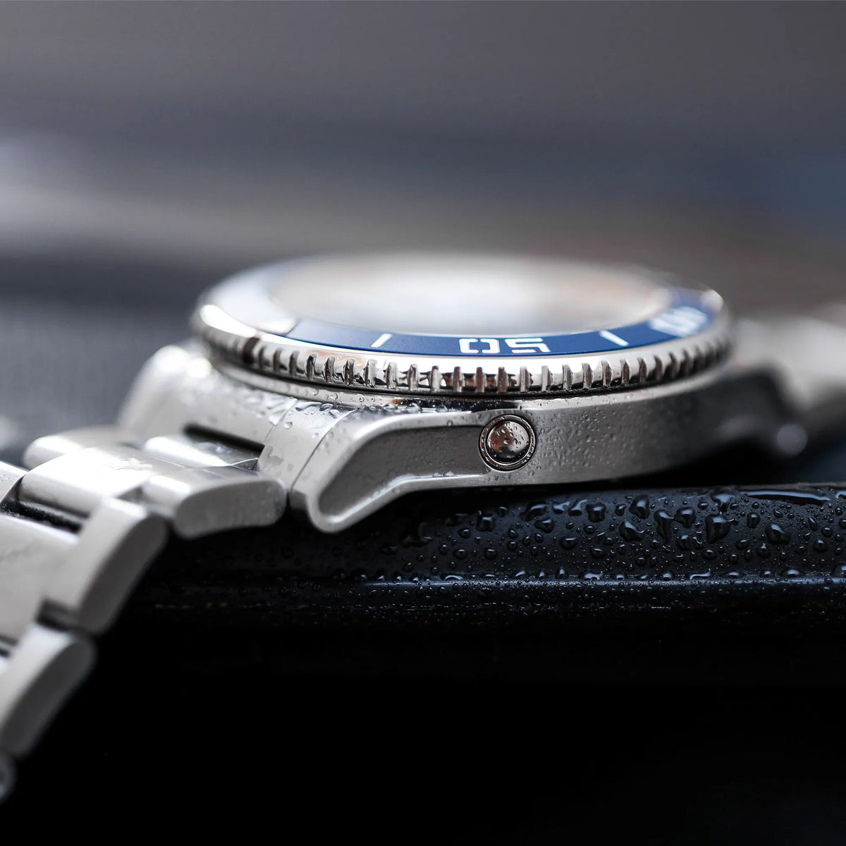 Produktfotografie der Hanhart Aquasphere mit dem blau-schwarz verlaufenden "Ocean Fade"-Zifferblatt und blauem Keramik-Inlay auf der Lünette am Edelstahlarmband