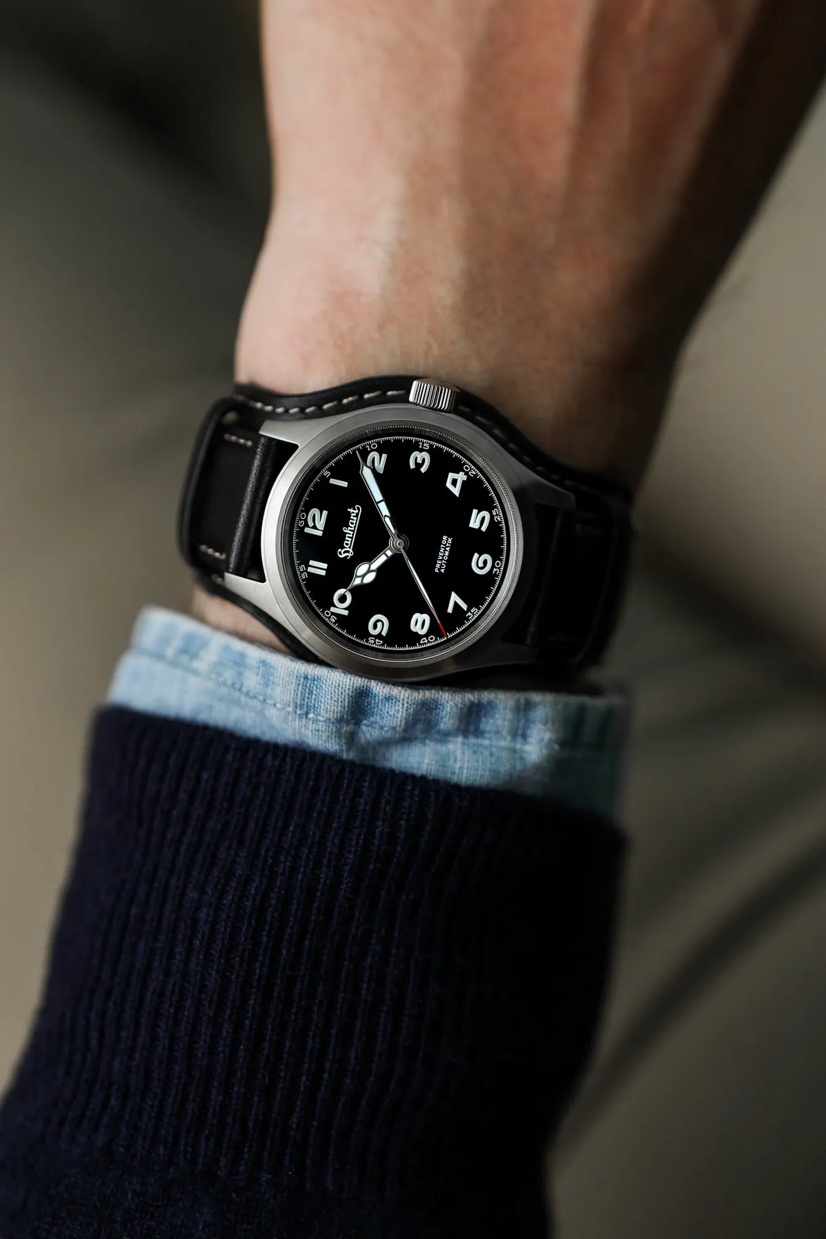 Mann trägt die Hanhart Preventor HD12 Dreizeiger-Uhr mit schwarzem Zifferblatt an seinem Handgelenk