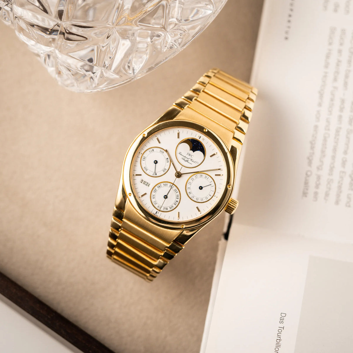 Fotografie der IWC Ingenieur Perpetual Calendar in Gelbgold mit weißem Zifferblatt und zughörigem Gelbgold-Armband aus der Vogelperspektive