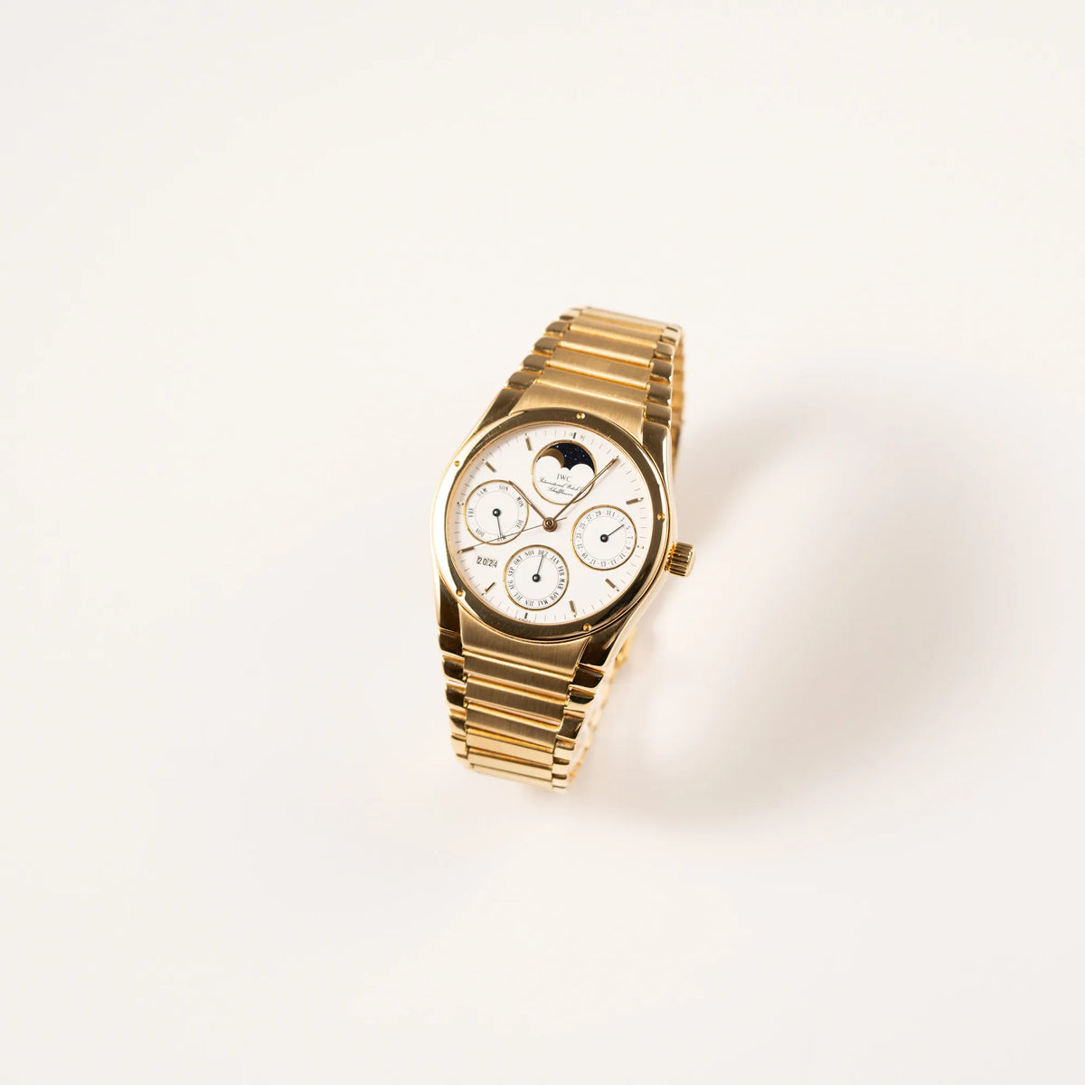 Leicht schräge Ansicht der IWC Ingenieur Perpetual Calendar in Gelbgold mit weißem Zifferblatt und zughörigem Gelbgold-Armband