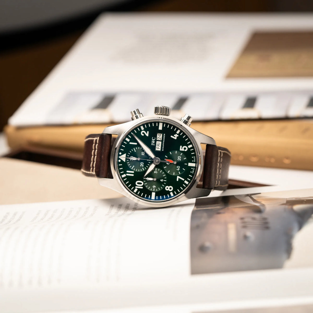 Produktfotografie des IWC Pilot 41 Chronographs IW388103 mit grünem Zifferblatt an einem braunen Lederband