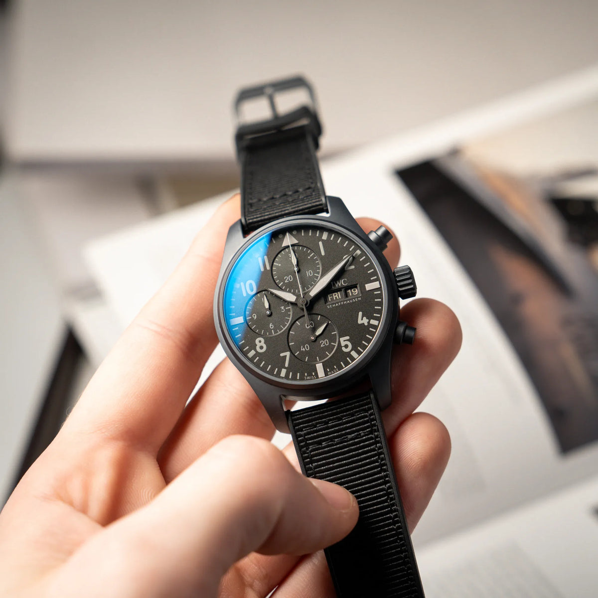 Mann hält den IWC Pilot 41 "Top Gun" Chronograph mit schwarzem Ceratanium-Gehäuse aus Keramik und Titan in seiner Hand