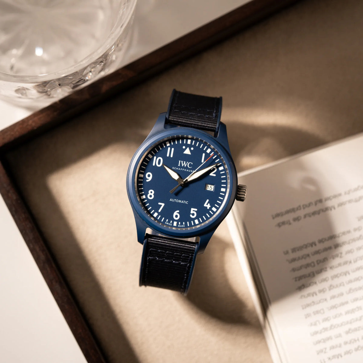 Produktfotografie aus der Vogelperspektive der limitierten IWC Pilot's Watch IW328101 "Laureus Sport for Good" mit blauem Keramik-Gehäuse